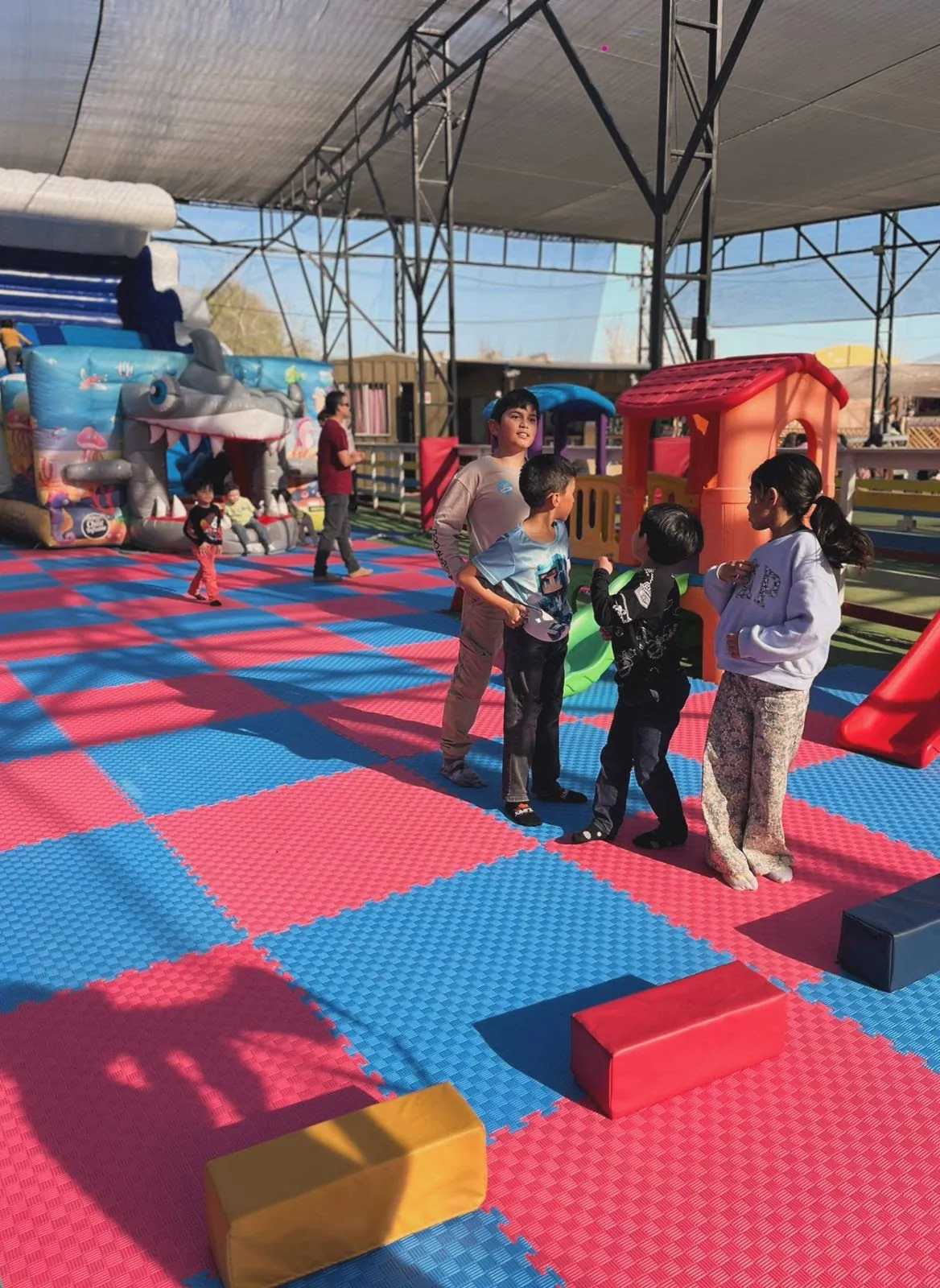 Grupo de niños jugando en la Zona Kids de Rayo Inflables con un monitor supervisando